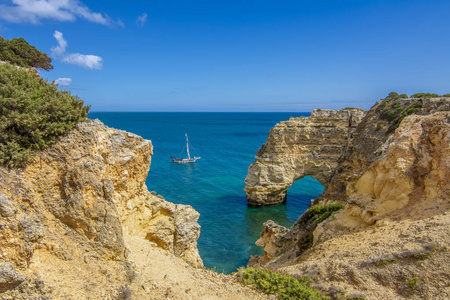 Marinha 海滩和绿松石海水本原在阿尔加维地区葡萄牙海岸的岩石悬崖上