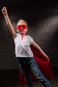 女孩子在红色超级英雄面具飞行