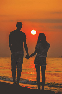 在海边看夕阳的恋人.选择性聚焦照片