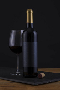 黑色木质背景和黑色标签的孤立红酒瓶