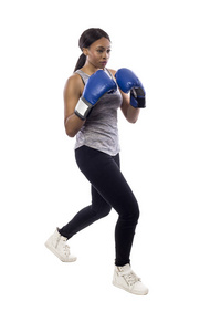 黑色女性被隔离在白色背景上身穿拳击手套与箱内健美操锻炼。她摆出一拳, 描绘了健身自卫和武术。