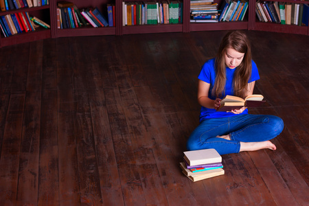 女孩坐在图书馆的地板上