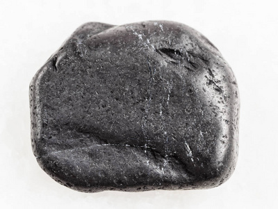 在白色大理石上暴跌的 shungite 宝石