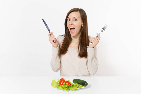 素食妇女在餐桌上用树叶沙拉生菜, 盘子里的蔬菜被隔绝在白色的背景上。适当的营养, 素食, 健康的生活方式节食的概念。带有复制空间