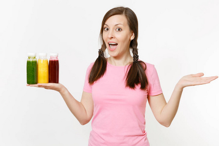 有趣的女人持有一排绿色, 红色, 黄色的排毒冰沙酒瓶在白色背景隔离。适当的营养, 素食饮料, 健康的生活方式, 节食的概念。复制