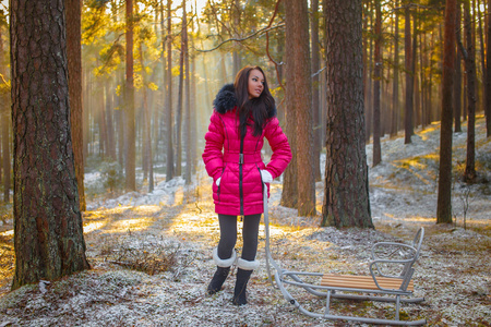 女孩穿着粉红色外套和雪橇的合影