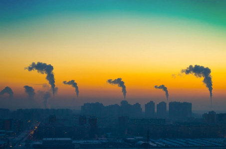 在日落时从烟囱排放黑烟的城市工业景观视界晚报