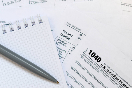 笔和笔记本是位于税表1040美国个人所得税的回报。纳税时间