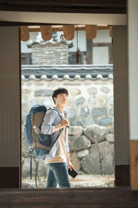 一个年轻男子在韩国传统的房子里做背包旅行