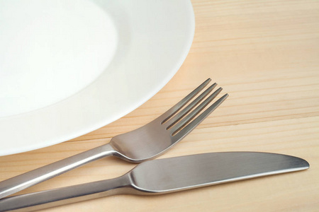 用刀子和叉子木制的桌子上的空盘子