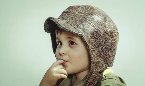 可爱的小学步男孩, 在家里玩战争和和平, 滑稽的孩子身着军用帽子和护目镜