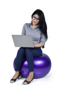 女企业家坐在球上的笔记本电脑