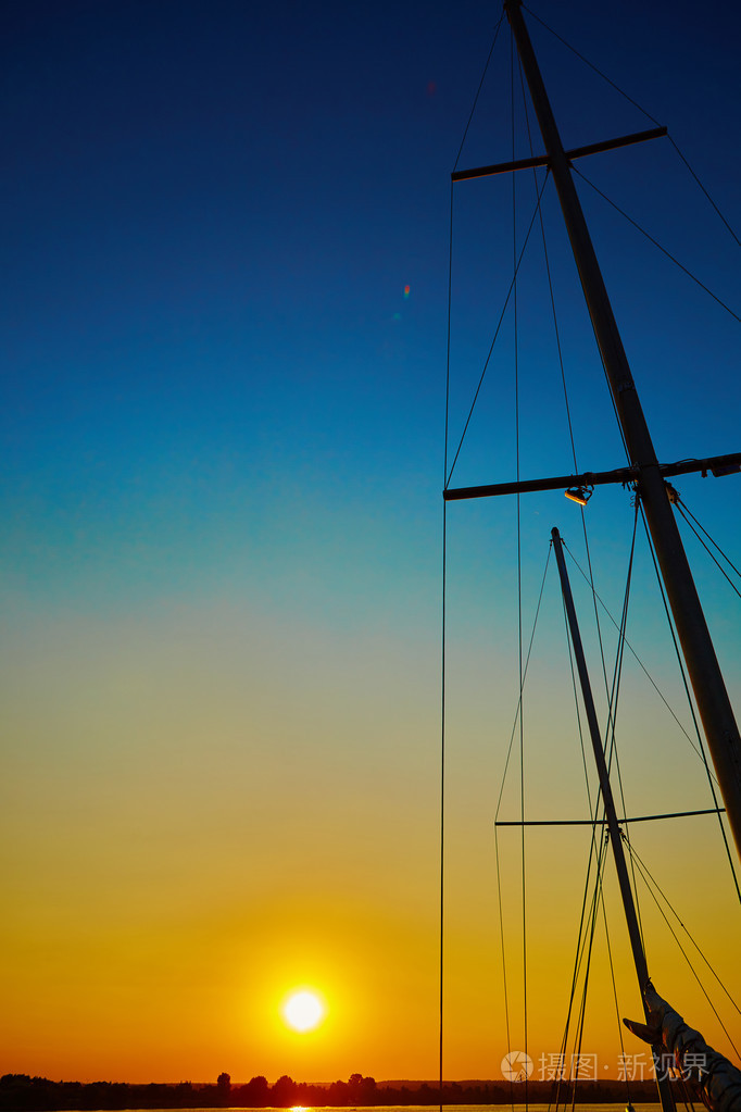 在日落时分在海上航行船滑翔