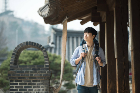 一位年轻男子在韩国传统的侯做背包旅行