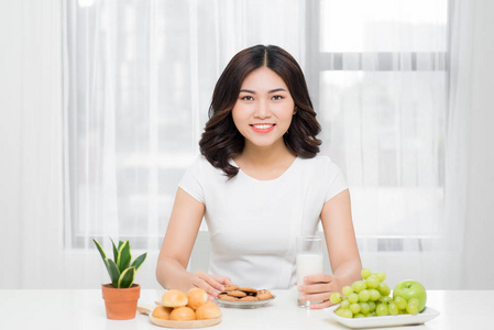 美丽的亚洲妇女坐在餐桌上与健康的食物照片