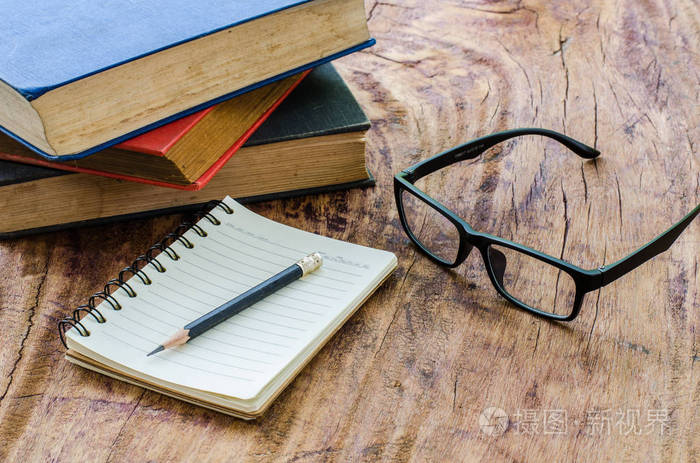 铅笔与眼镜在木地板上放一堆书和笔记本