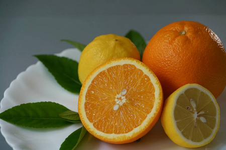 有机橙和柠檬与灰色的背景分离的白板上