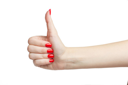大拇指的手势与修剪整齐的红指甲分离在白色的背景照片