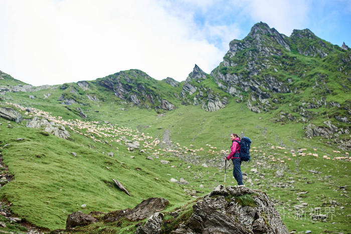 在罗马尼亚年轻的女登山者站在岩石边缘欣赏着绿色的
