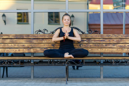 年轻女子练金刚瑜伽坐在板凳上