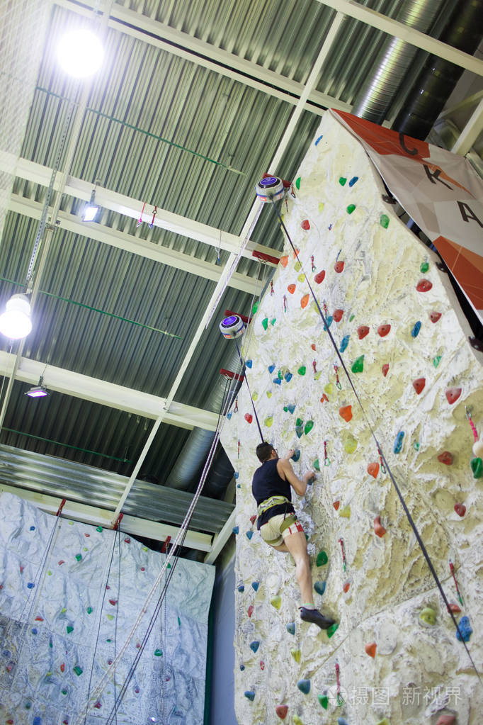攀爬在人工墙室内运动小伙子