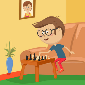 小男孩戴着眼镜下棋坐在房间里的沙发上照片