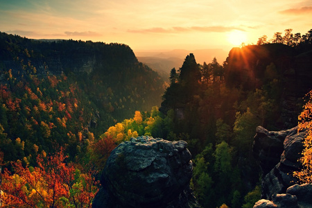 在岩石中的秋天日落。查看在砂岩岩石落波希米亚瑞士多彩谷