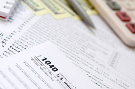 钢笔, 笔记本, 计算器, 和美元是在税形式1040美国个人所得税回归。纳税时间
