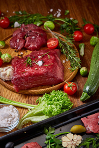 生牛肉与蔬菜在木盘子上的生活在老式背景, 顶级视图, 选择性焦点