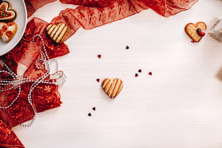 装饰心形饼干, 红丝带和红色闪光的心在背景上的顶部视图