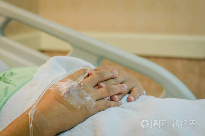 男病人躺在医院的病床上接受生理盐水的手