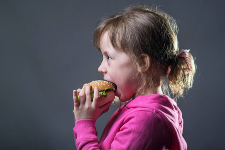 女孩吃快餐, 在灰色背景上的肖像