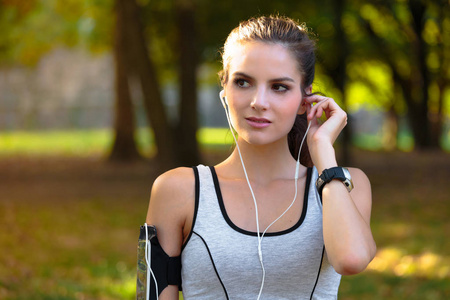 听音乐带着耳机的女子赛跑运动员照片