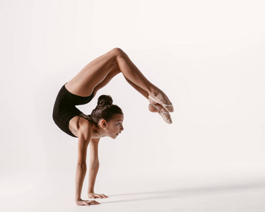 年轻体操运动员女孩舒展和训练照片