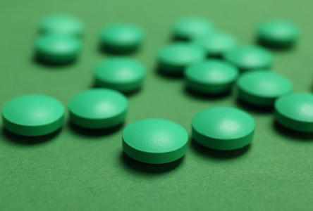 特写一堆白色的药丸,绿色的针剂和温度计绿色药片,泡罩包装,图案霉圹