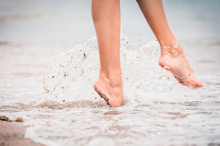 夏天在海上的女孩赤脚进入水中