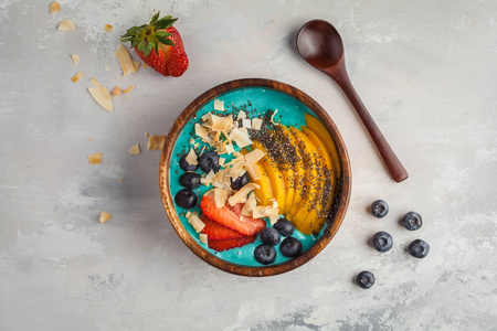 浆果蓝色冰鲜碗芒果和椰子, 顶部视图, 复制