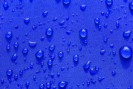 在蓝色防水布背景上关闭水滴图案。世界水日概念