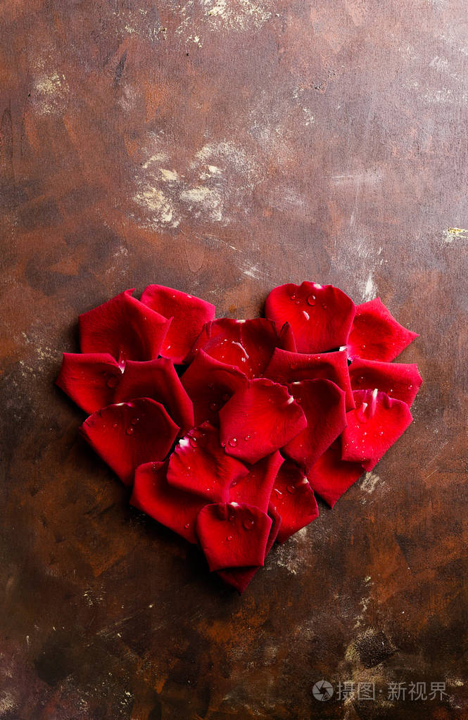 顶部视图平躺在黑暗背景的心脏形状的红色玫瑰花瓣浪漫激情的概念情人