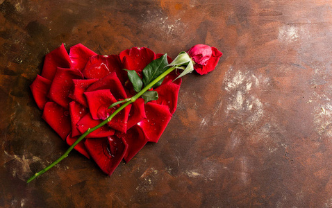 顶部视图平躺在黑暗背景的心脏形状的红色玫瑰花瓣。浪漫, 激情的概念。情人节。文本空间