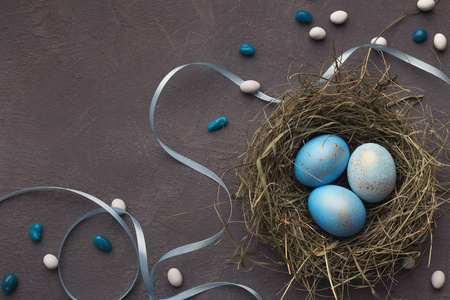 复活节背景。灰石表面巢中的彩色蛋