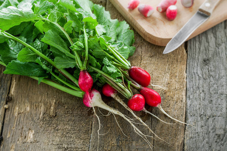 一捆健康的有机萝卜放在一张木桌上。新鲜健康蔬菜