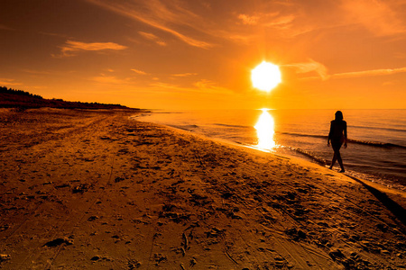 日落海滩。在太阳, 夏天背景, 波罗的海, 波兰的妇女漫步在海