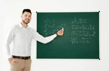 男教师在课堂上讲解黑板附近的材料