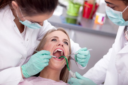牙医在治疗的女性患者的牙齿