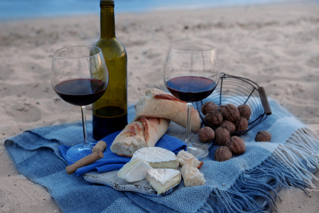 美丽的浪漫组成的红酒 面包和沙滩上的螺母