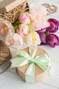 新鲜的粉红色郁金香花在礼物牛皮纸盒