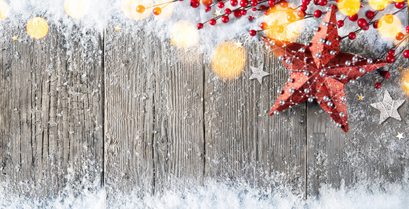 圣诞贺卡与星星装饰和浆果在白雪皑皑的木头上