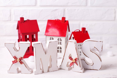 词圣诞节由木信件和装饰的房子在白色木质背景。圣诞节背景