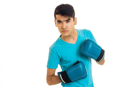 严重的黑发拳击手运动员在蓝色的手套，看着相机孤立在白色背景上的肖像